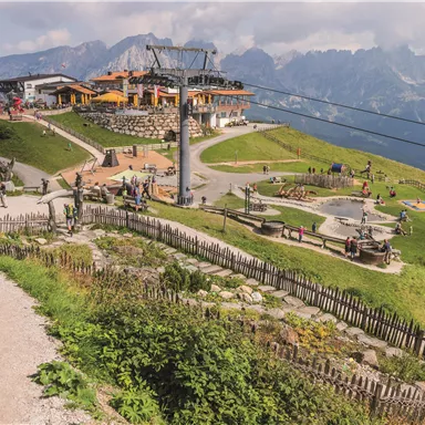 A picturesque mountain landscape with a recreational area and restaurant. People enjoy nature and outdoor activities.
