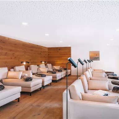 A quiet relaxation area with comfortable loungers and warm wooden decor. The cozy atmosphere invites you to relax.