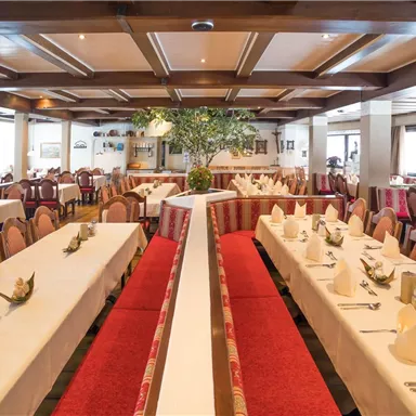 Ein einladendes Restaurant mit eleganten Tischen und Stühlen. Die Atmosphäre ist gemütlich und gut beleuchtet.