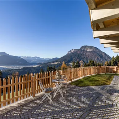 A terrace overlooking the mountains and a picturesque landscape. The sky is clear and the sun is shining.