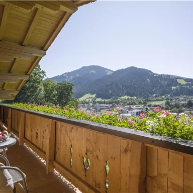 A beautiful balcony with a view of the mountains and the city. The flowers give the terrace an inviting atmosphere.