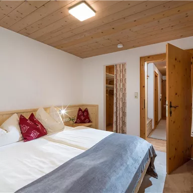 Ein gemütliches Schlafzimmer mit zwei Einzelbetten und hellen Holzvertäfelungen. Die Inneneinrichtung ist schlicht und einladend.