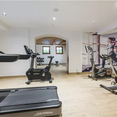 A modern gym with treadmills and fitness equipment. The walls are decorated with motivating images of athletes.