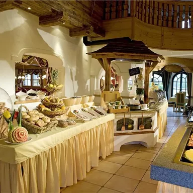 An inviting buffet with various dishes and fresh foods. The room is bright and friendly, ideal for a cozy meal.