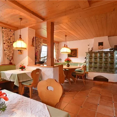 A cozy restaurant with wooden decor and warm colors. The tables are elegantly set and decorated with flowers.