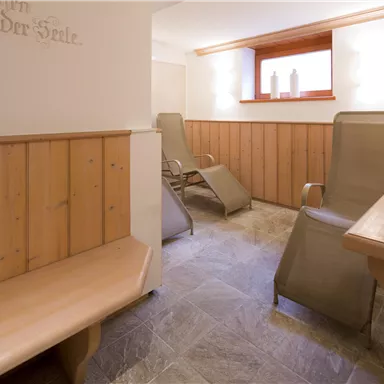 Ein ruhiger Wellnessbereich mit Holzverkleidung und bequemen Liegen. Sanftes Licht und eine entspannende Atmosphäre laden zur Erholung ein.