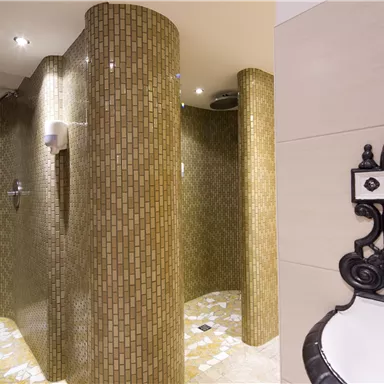 Moderne Duschen mit goldfarbenen Fliesen und einem eleganten Design. Der Raum strahlt eine entspannende Atmosphäre aus.