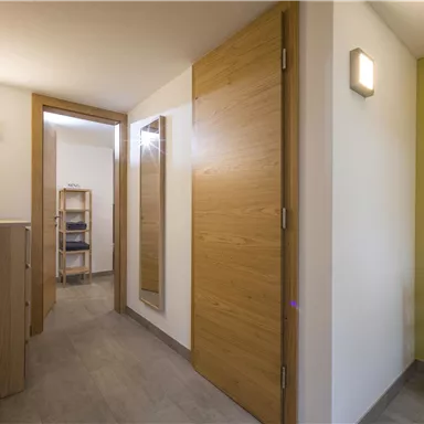 Ein heller Flur mit modernem Design. Holz- und graue Wände schaffen eine einladende Atmosphäre.