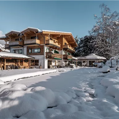 Ein schönes Gebäude im Winter mit Schnee bedecktem Garten. Der Himmel ist blau und die Landschaft wirkt friedlich.