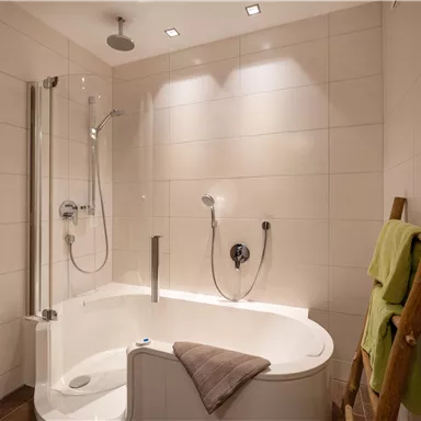 Ein modernes Badezimmer mit einer komfortablen Badewanne und einer separaten Dusche. Die Wände sind hell gefliest und es gibt einige handtücher an einem Holzregal.