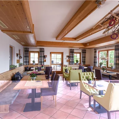 Ein gemütliches Restaurant mit Holzdekor und bunten Stühlen. Die Räume sind hell und einladend, ideal für eine entspannte Atmosphäre.