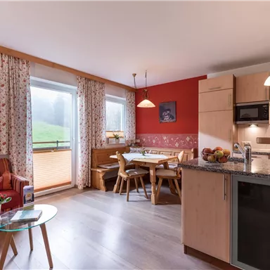 Cozy living kitchen with dining table and sofa area.