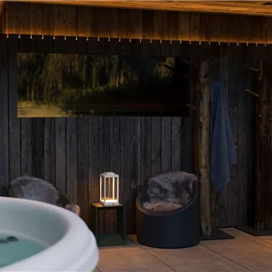 A relaxing spa area with a whirlpool and cozy chairs. The wood paneling and soft lighting create an inviting atmosphere.