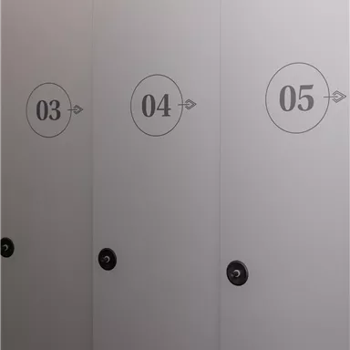 Drei geschlossene Türen mit den Nummern 03, 04 und 05. Die Türen sind schlicht und modern gestaltet.