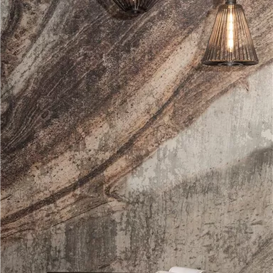 Ein moderner Raum mit einer strukturierten Wand und zwei stylischen Lampen. Ein schwarzer Tisch mit einer Zeitschrift ergänzt das Ambiente.