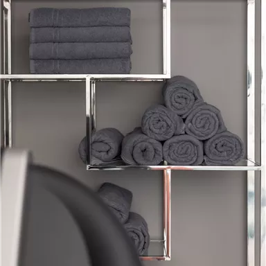 A modern towel shelf with gray towels in different arrangements. The background is kept subtle and light.