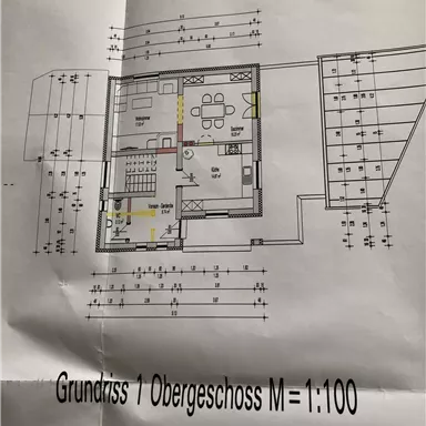 Ein Grundriss für das Obergeschoss eines Gebäudes, dargestellt im Maßstab 1:100. Die Zeichnung zeigt verschiedene Räume, darunter Wohn- und Schlafbereiche.