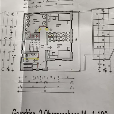 Ein Grundriss für das zweite Obergeschoss im Maßstab 1:100. Die Darstellung zeigt die Aufteilung der Räume und Möbel.