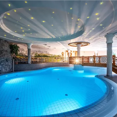 A relaxing indoor pool with clear blue water and an elegant ceiling. The cozy atmosphere invites you to unwind.