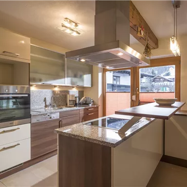 Modern kitchen with wooden and white furniture. Large windows provide plenty of light and a friendly atmosphere.