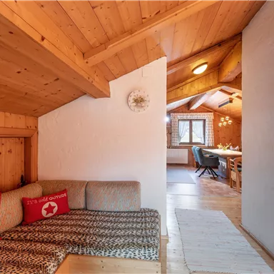 A cozy wooden cabin with a seating area and a warm ambiance. The space is bright and inviting, perfect for relaxing hours.