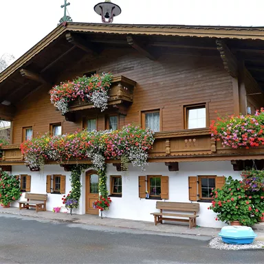 A rustic wooden house with colorful flower boxes on the balconies. The facade is picturesque and inviting.