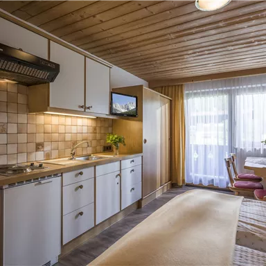 Eine gemütliche Küche mit Holzdecken und modernen Geräten. Der Raum ist hell und freundlich mit viel natürlichem Licht.