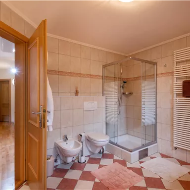 Ein grosses Badezimmer mit zwei Waschbecken, einer Dusche, Badewanne, Toilette und Bidet . Der Raum ist hell und gut beleuchtet.