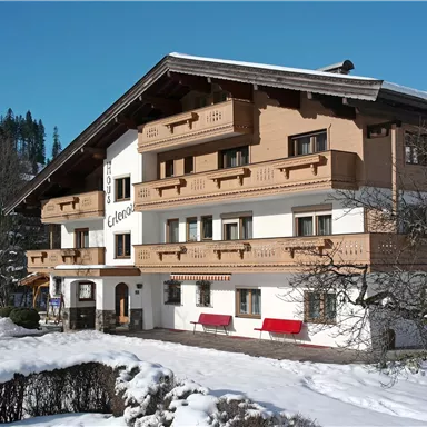 A cozy chalet in the snow with a wood-clad facade. The surroundings are wintry and invite relaxation.