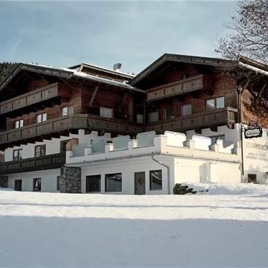 An Alpine chalet in the snow, surrounded by mountains. The wooden architecture and winter magic give the scene a cozy atmosphere.
