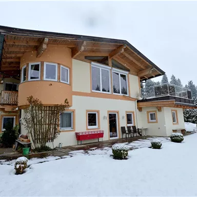 A charming house in the snow with a large garden. The surroundings are surrounded by snowy trees.