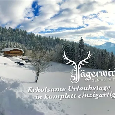 Eine winterliche Landschaft mit viel Schnee und einem Holzhaus. Der Himmel ist teilweise bewölkt und es gibt Wälder im Hintergrund.