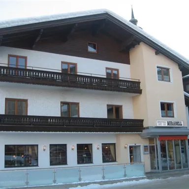 Ein charmantes Gebäude mit einem Mix aus Holz- und Putzfassade. Die Fensterläden und Balkone verleihen dem Haus einen traditionellen alpinen Stil.
