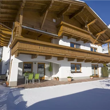 A modern house in winter, surrounded by fresh snow. The large balcony and terrace invite you to relax.
