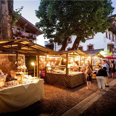 Ein schöner Nachtmarkt mit bunten Ständen und vielen Besuchern. Die Atmosphäre ist lebhaft und einladend unter dem Abendhimmel.