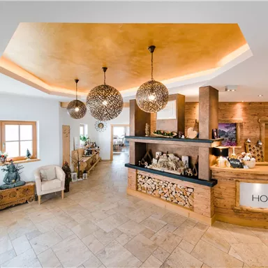 Eine moderne Rezeption mit warmen Holzelementen und stilvollen Pendelleuchten. Der Raum ist hell und einladend, ideal für einen angenehmen Empfang.