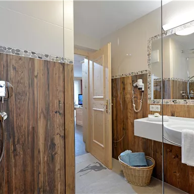 Bright bathroom at Hotel Alpenpanorama in the Wilder Kaiser holiday region with shower, sink, and high-quality features.