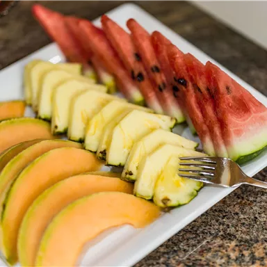 A plate with fresh fruits, including melons, pineapple, and cantaloupe. The colors are vibrant and inviting.
