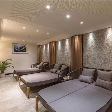 Ein stilvoller Wellnessbereich mit Liegen und sanfter Beleuchtung. Die Atmosphäre ist entspannend und einladend.