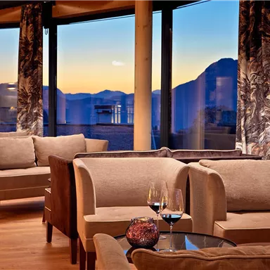 An elegant room with comfortable sofas and an impressive view of the mountains. The atmosphere is warm and inviting, perfect for relaxed enjoyment.