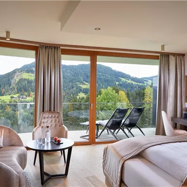 A modern room with large windows that provide a beautiful view of the mountains. The decor is elegant and cozy, perfect for relaxation.
