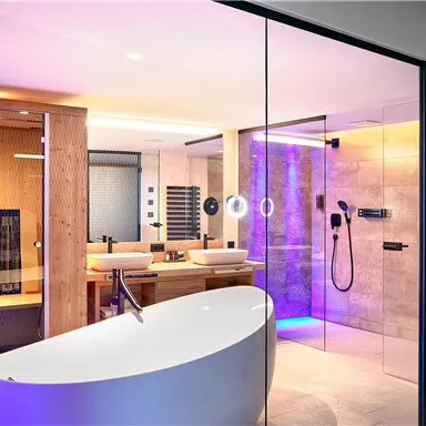 A modern bathroom with a freestanding bathtub and a spacious shower. The room is designed with soft lighting and elegant wooden elements.