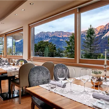 An elegant restaurant with wooden furniture and an idyllic view of the mountains. Large windows let in plenty of daylight and offer a breathtaking view of nature.