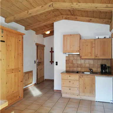 Ein gemütlicher Küchenraum mit Holzverkleidung und einem praktischen Layout. Die hellen Fliesen und Holzdetails schaffen eine warme Atmosphäre.