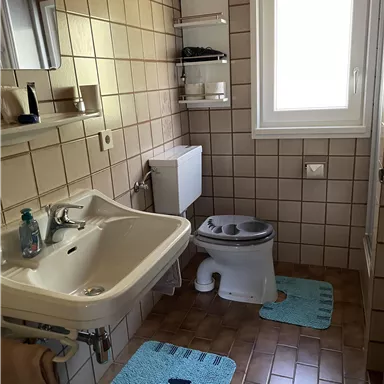 This bathroom belongs to the wooden bed room