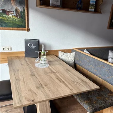 A cozy wooden table in a restaurant. In the background, there is a bench and some decorative items visible.