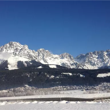 Eine beeindruckende Berglandschaft mit schneebedeckten Gipfeln und klarem blauen Himmel. Die Umgebung ist ruhig und malerisch, ideal für Wintersportaktivitäten.