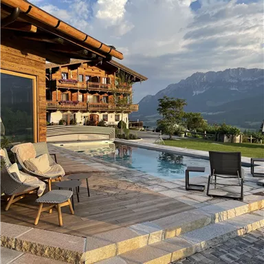 A picturesque terrace with a view of the mountains and a pool. The surroundings are designed for relaxation and enjoying nature.
