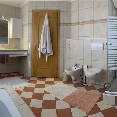 Ein modernes, großzügiges Badezimmer mit zwei Waschbecken, einer Dusche, Toilette, Bidet und Badewanne.