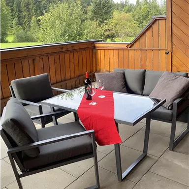 Ein gemütlicher Sitzbereich auf der Terrasse mit einem Tisch und bequemen Stühlen.